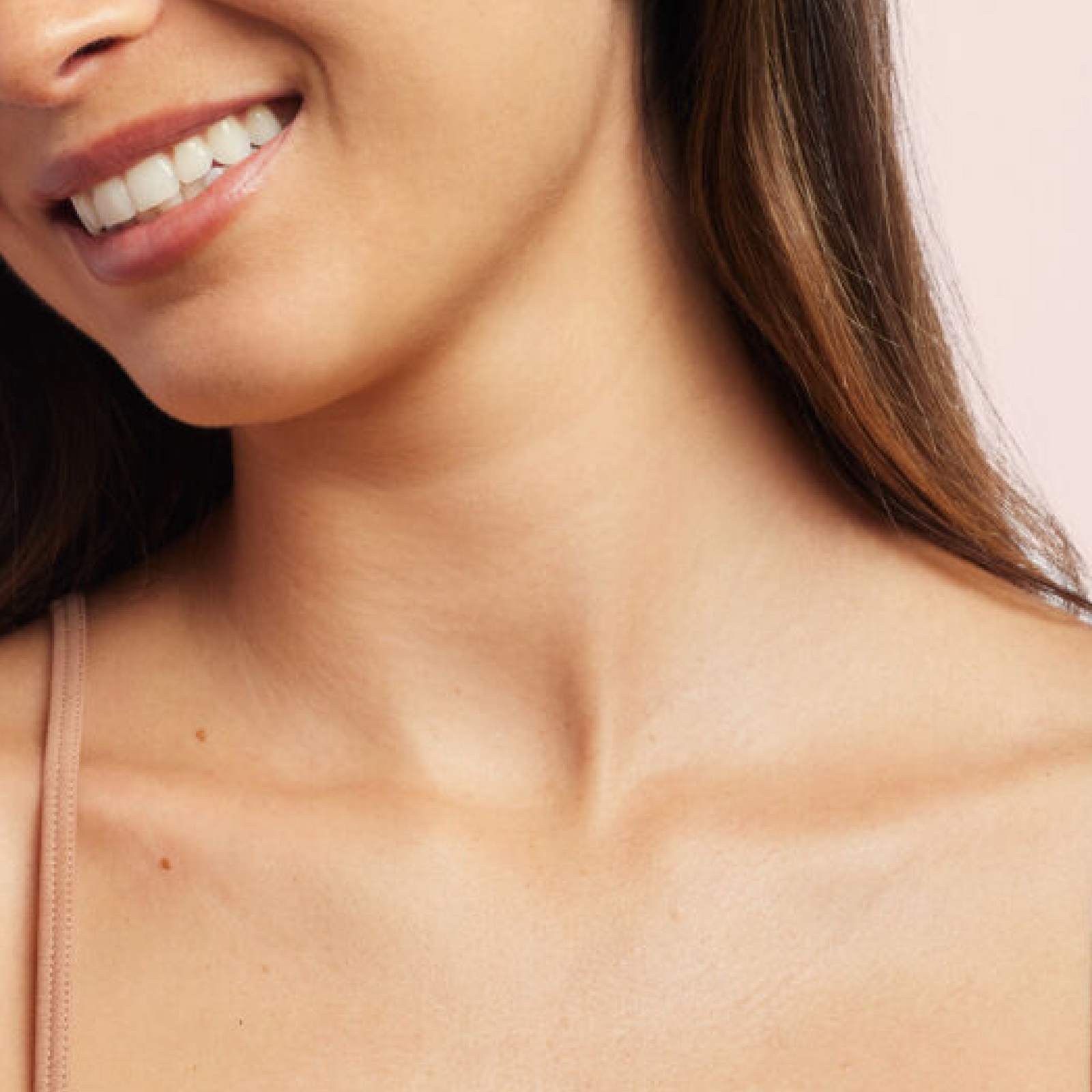 Close-up of smiling woman’s collarbone and neckline.